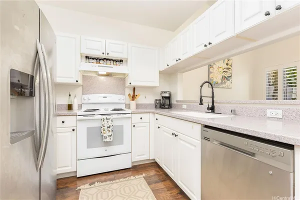 a kitchen with stainless steel appliances a sink stove refrigerator and cabinets