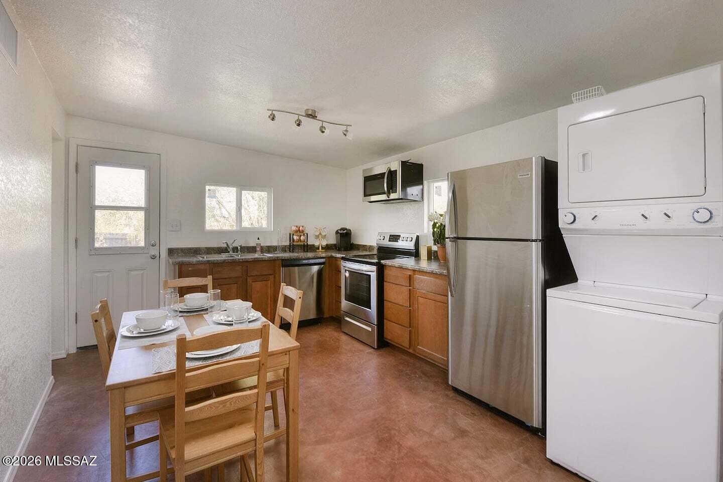 4415 North Swan Road Tucson, AZ 85718 - Photo 7 of 33 a kitchen with a refrigerator a stove a sink dishwasher and white cabinets with wooden floor