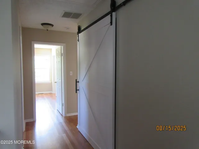 a view of a hallway with wooden floor