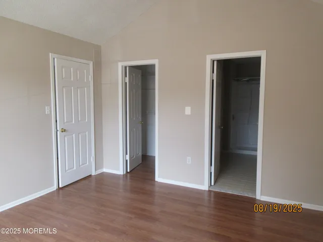 an empty room with wooden floor and closet