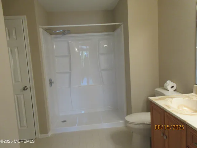 a bathroom with a granite countertop sink a toilet and shower