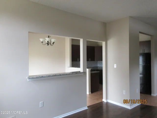 an empty room with wooden floor and cabinet