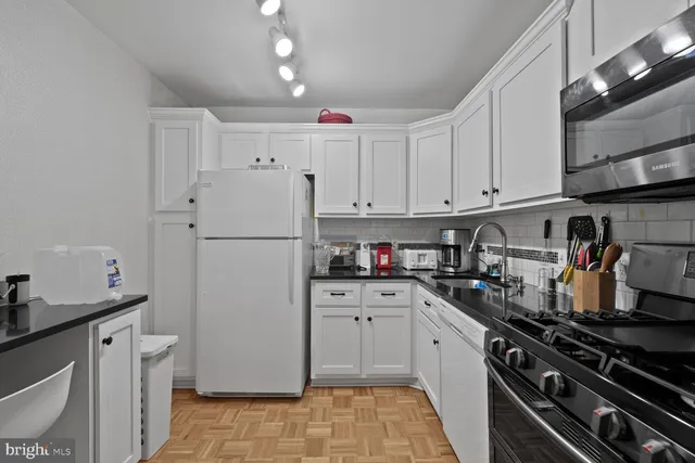 a kitchen with stainless steel appliances a refrigerator sink and cabinets
