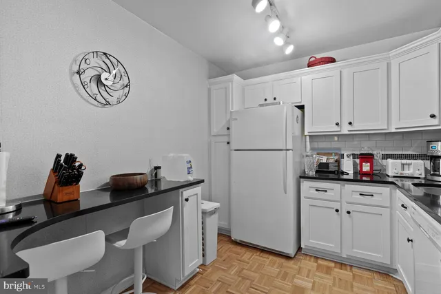a kitchen with granite countertop a sink cabinets and stainless steel appliances