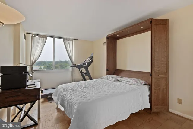 a bedroom with a bed and a large window