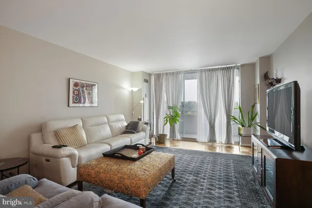 a living room with furniture a flat screen tv and a window