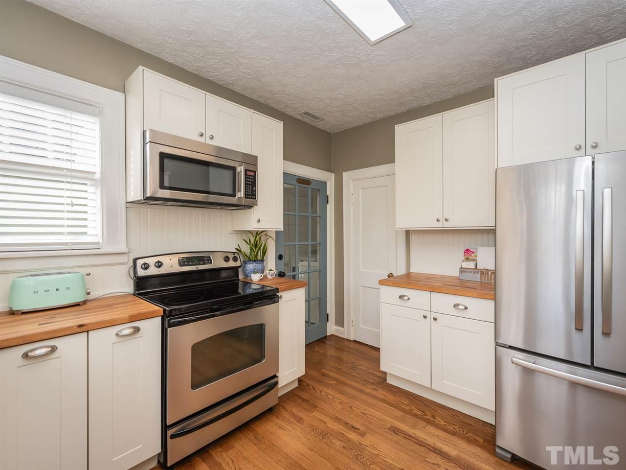 612 North Boundary Street Raleigh, NC 27604 - Photo 16 of 28 a kitchen with cabinets stainless steel appliances a sink and wooden floor