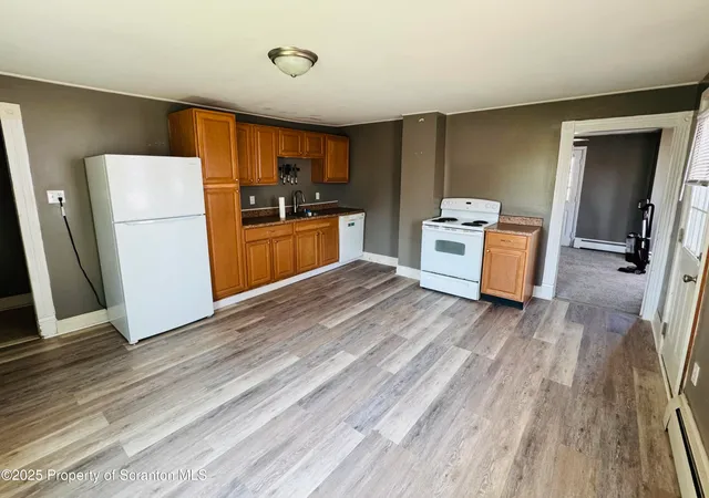 a kitchen with a refrigerator and a stove top oven