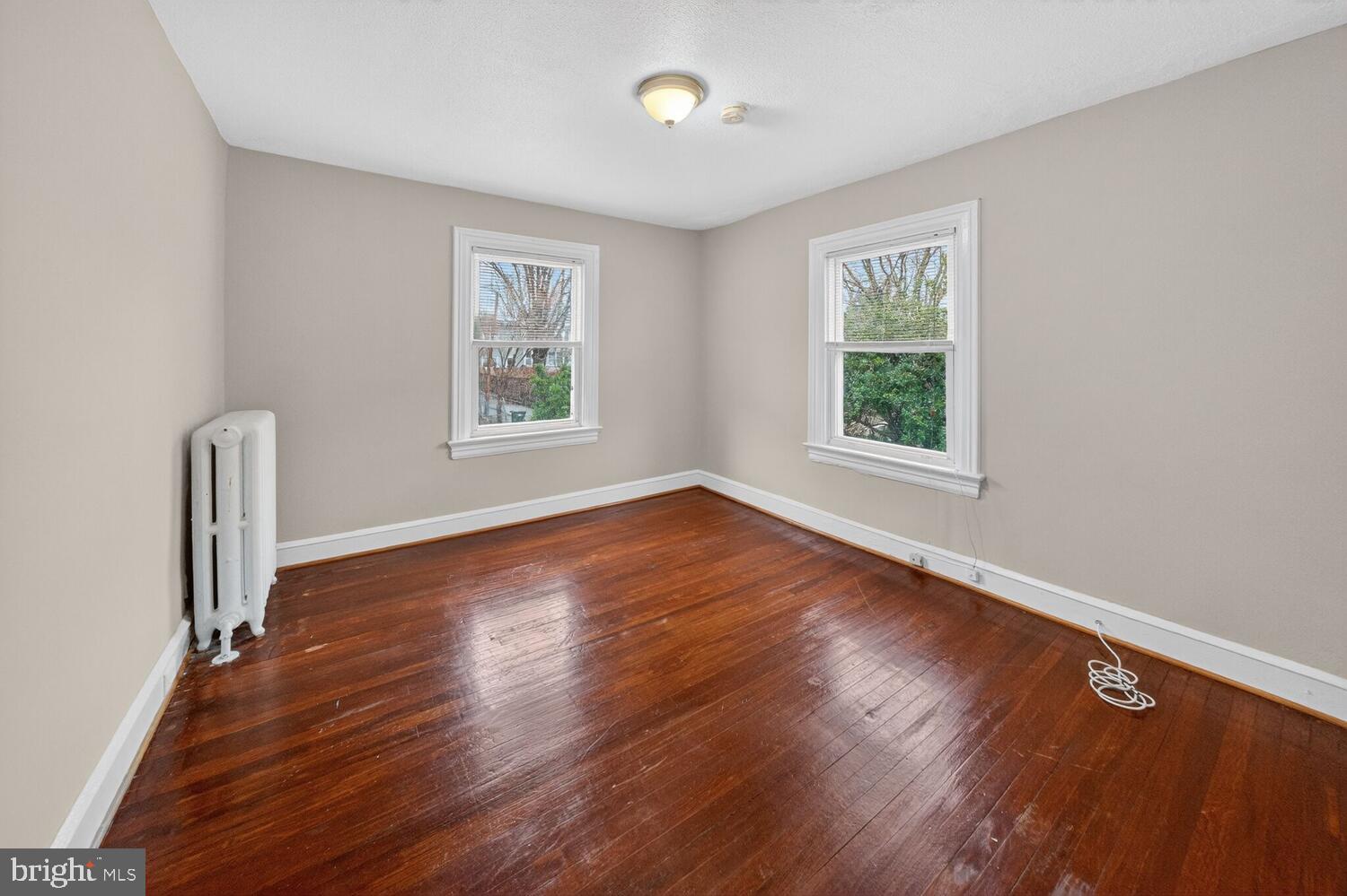 1353 Kennedy Street Northwest Washington, DC 20011 - Photo 16 of 32 a view of an empty room with wooden floor and a window