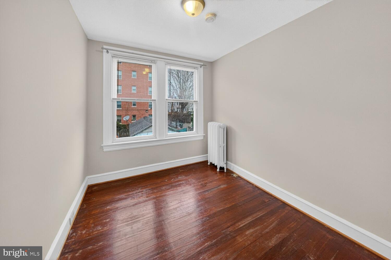 1353 Kennedy Street Northwest Washington, DC 20011 - Photo 18 of 32 an empty room with wooden floor and windows
