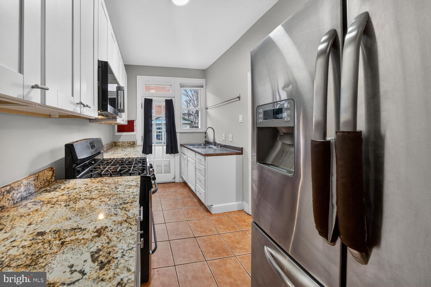 1353 Kennedy Street Northwest Washington, DC 20011 - Photo 8 of 32 a kitchen with stainless steel appliances granite countertop a refrigerator and a stove top oven