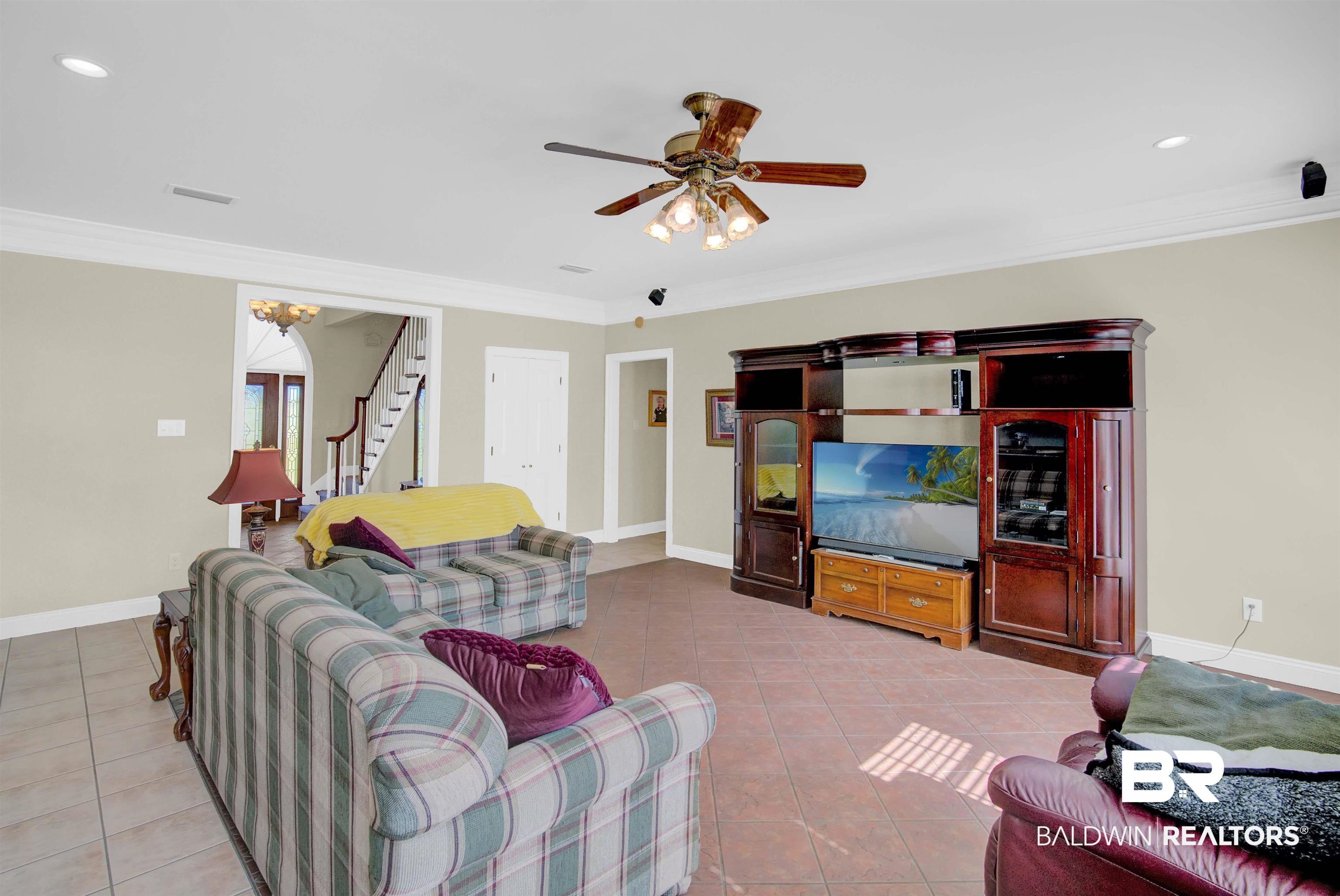 27688 Rigsby Road Daphne, AL 36526 - Photo 13 of 56 Tiled living room with ceiling fan and crown molding