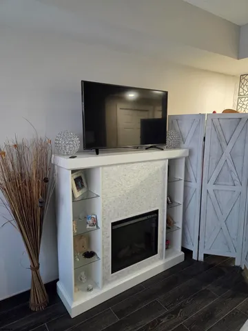 a living room with a fireplace furniture and a flat screen tv