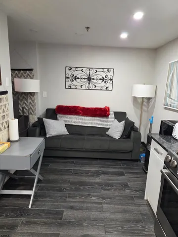 a living room with furniture and a wooden floor