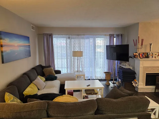 a living room with furniture a flat screen tv and a fireplace