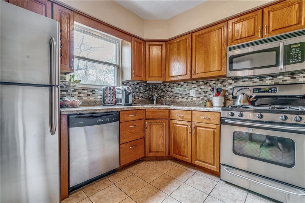 6 Virginia Terrace Pittsburgh, PA 15229 - Photo 10 of 23 a kitchen with stainless steel appliances granite countertop a stove microwave and cabinets