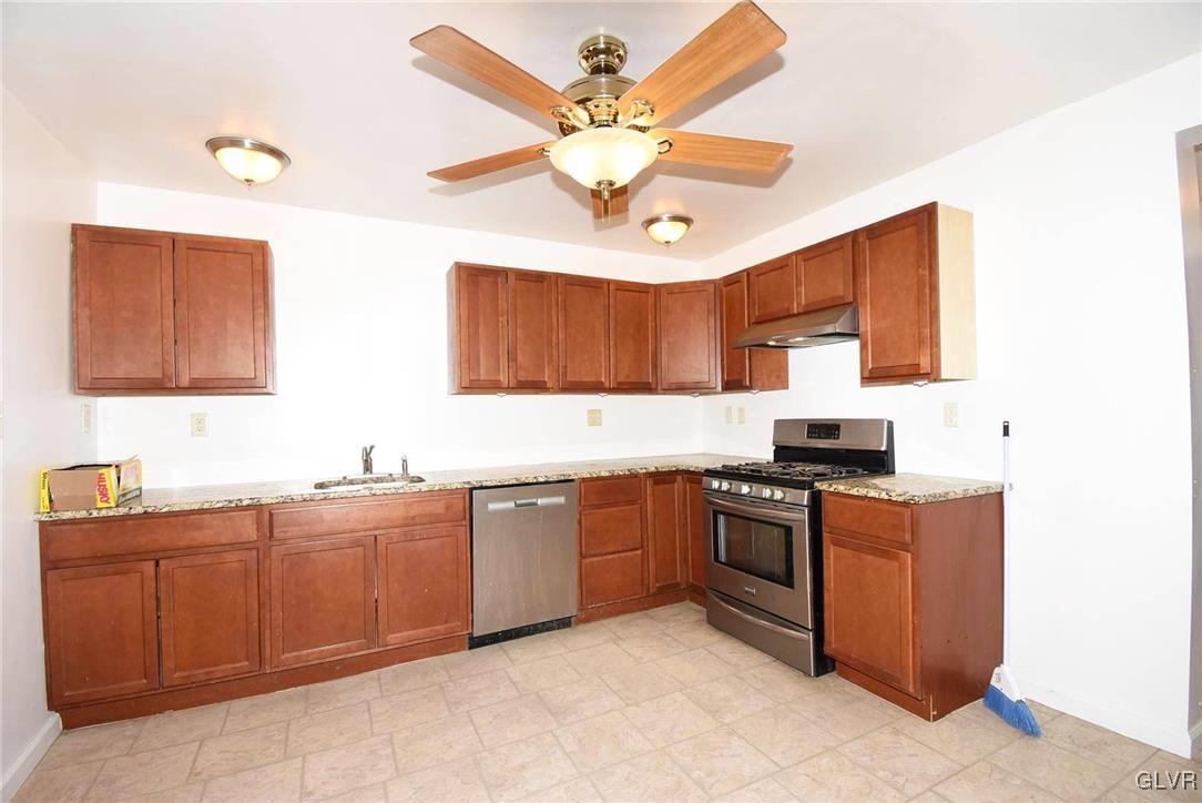 121 Main Street Hellertown, PA 18055 - Photo 3 of 29 a kitchen with stainless steel appliances granite countertop a sink dishwasher stove top oven and cabinets