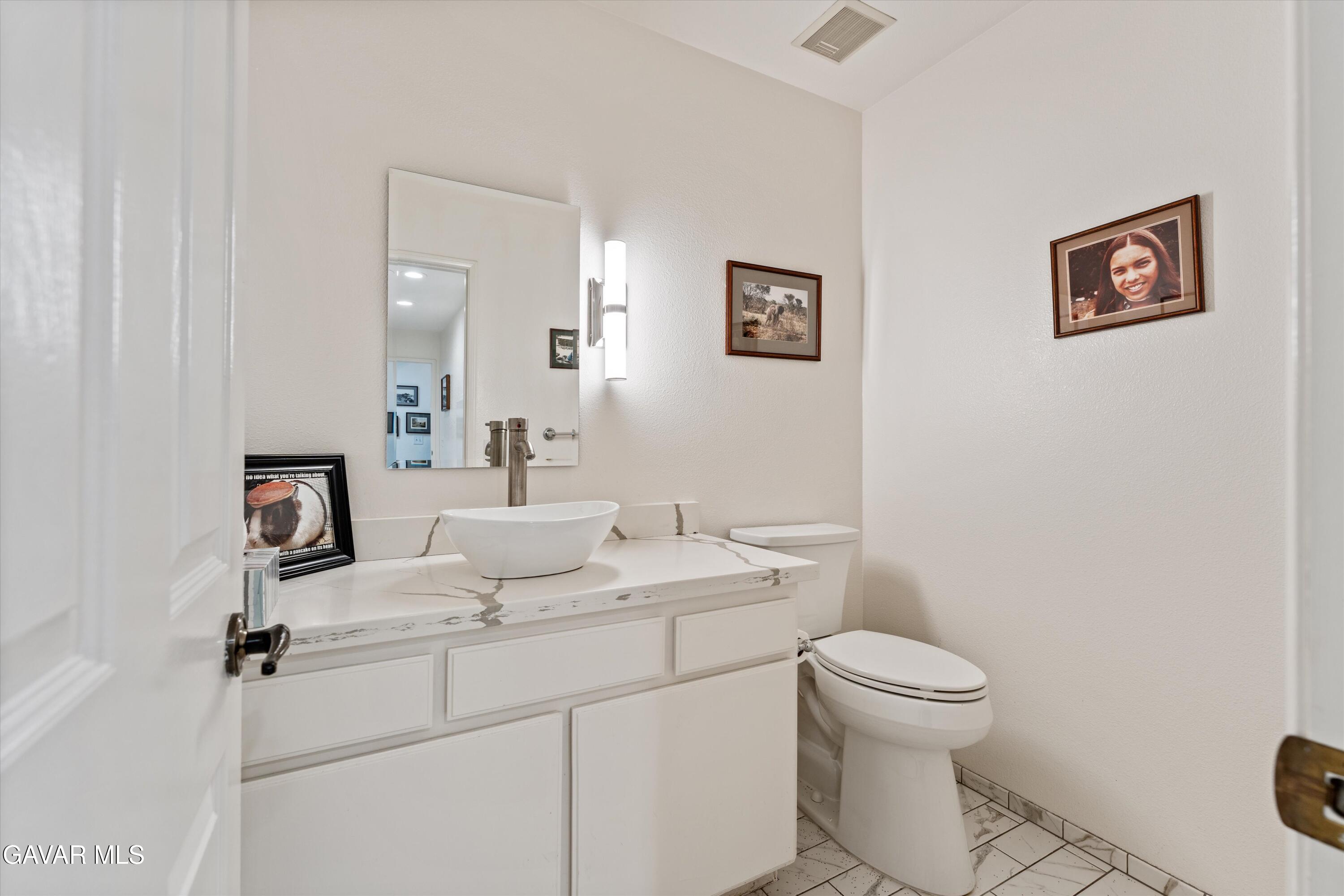 236 Hawk Lane Palmdale, CA 93551 - Photo 11 of 23 a bathroom with a toilet sink and mirror