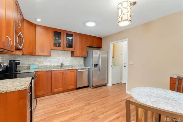 a kitchen with stainless steel appliances granite countertop a sink refrigerator and cabinets