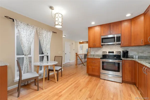 a kitchen with stainless steel appliances wooden floors and wooden cabinets