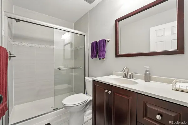 a bathroom with a sink vanity mirror and toilet