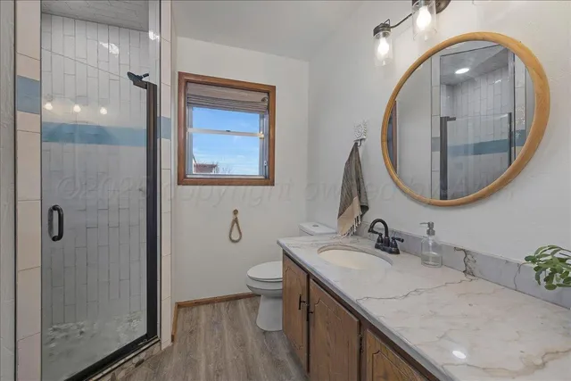 a bathroom with a granite countertop sink a toilet and a mirror