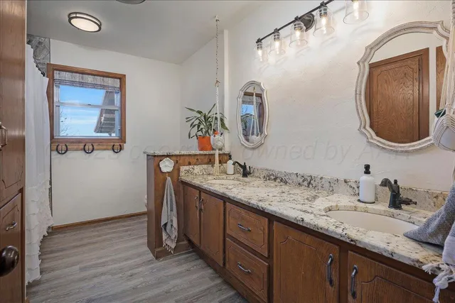 a bathroom with a granite countertop double vanity sink and a mirror