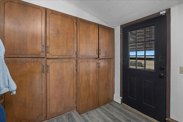 an empty room with wooden floor and cabinet