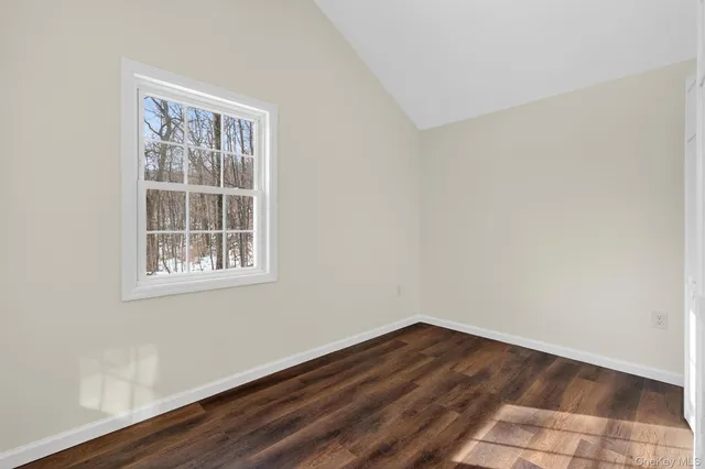 an empty room with wooden floor and entrance
