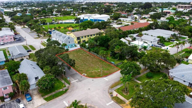 an aerial view of residential houses with outdoor space and trees