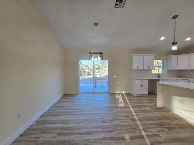 a view of an empty room and window with wooden floor