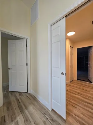 a view of kitchen and hall with wooden floor