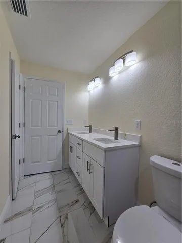 an empty room with wooden floor closet and fan
