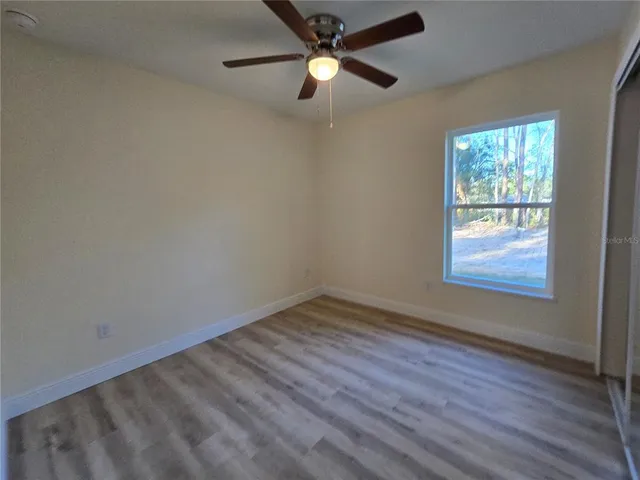 a view of a room with wooden floor and a bathroom