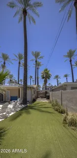 a view of a swimming pool with a lawn chairs under an umbrella