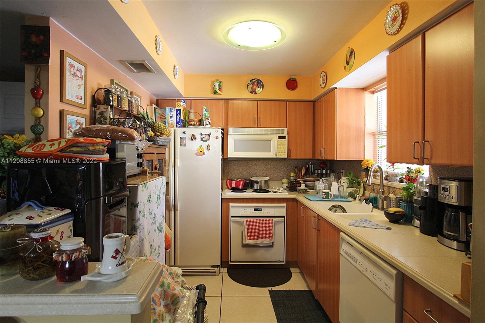 a kitchen with a sink appliances cabinets and a window