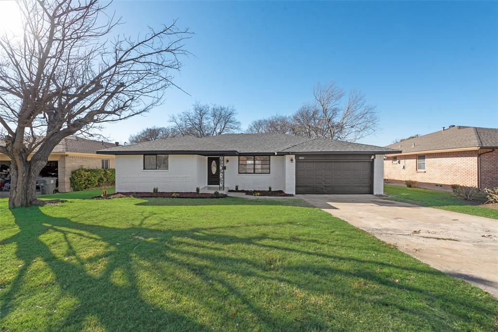 a front view of a house with a garden and trees