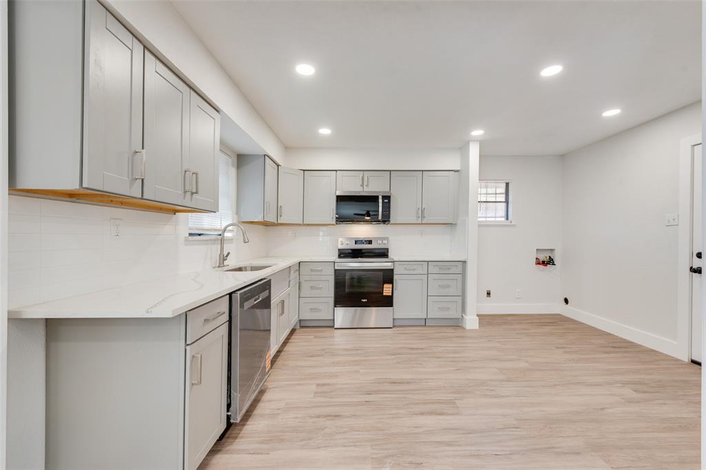 5311 Rocky Ridge Road Dallas, TX 75241 - Photo 13 of 24 a kitchen with granite countertop a stove top oven and cabinets