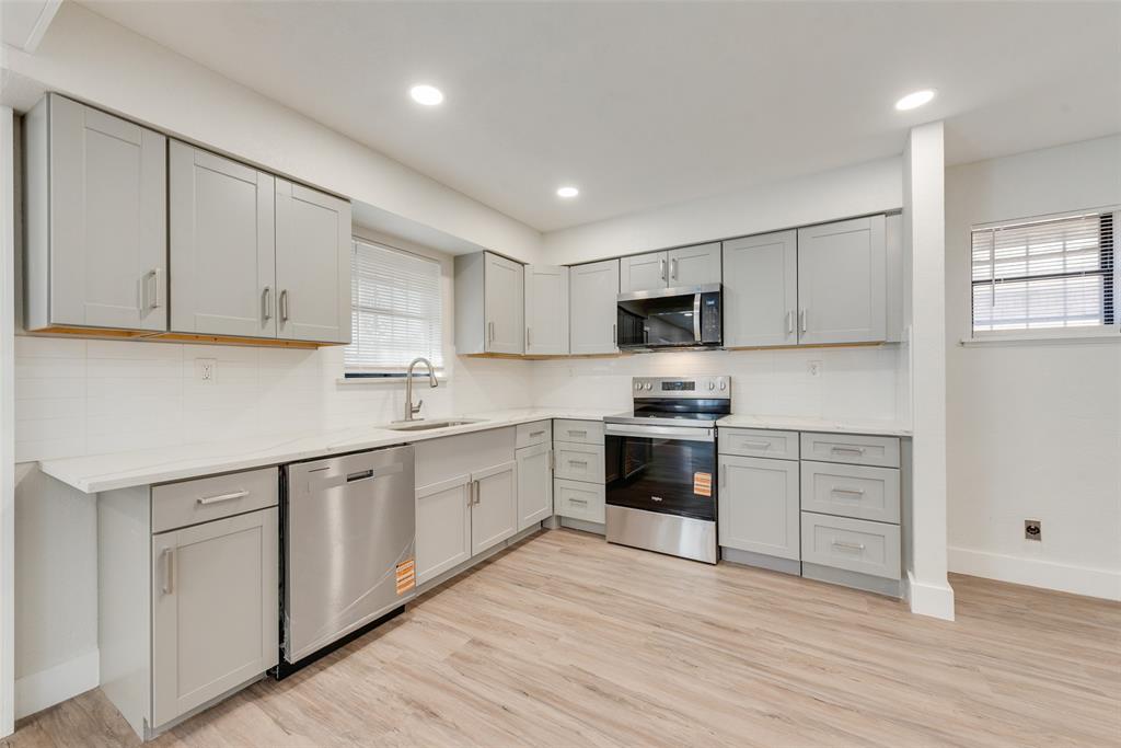 5311 Rocky Ridge Road Dallas, TX 75241 - Photo 14 of 24 a kitchen with granite countertop white cabinets and stainless steel appliances