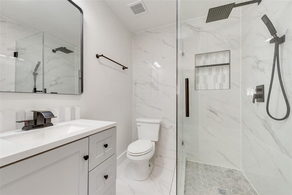 5311 Rocky Ridge Road Dallas, TX 75241 - Photo 19 of 24 a bathroom with a granite countertop sink a toilet and shower