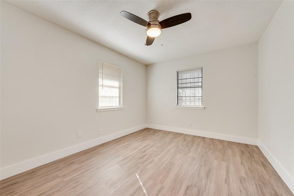 5311 Rocky Ridge Road Dallas, TX 75241 - Photo 21 of 24 an empty room with wooden floor ceiling fan and windows