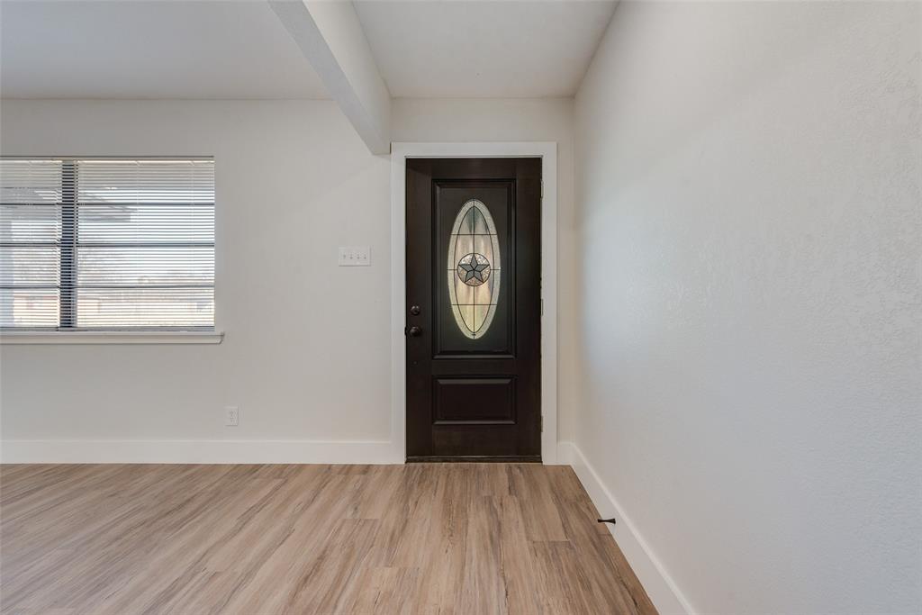 5311 Rocky Ridge Road Dallas, TX 75241 - Photo 5 of 24 a view of a hallway with wooden floor and a window