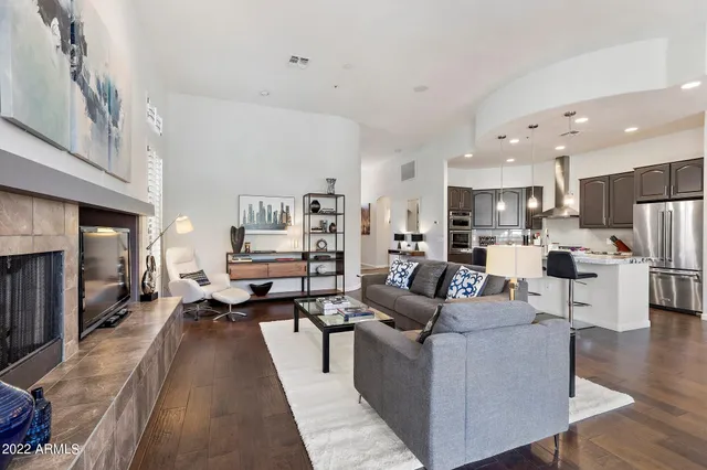 a living room with furniture kitchen view and a refrigerator