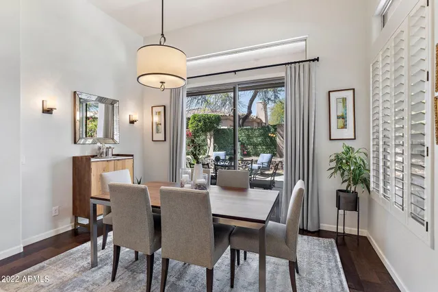a dining room with furniture potted plants and wooden floor