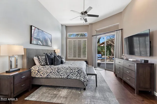 a bedroom with a large bed and a flat tv screen on dresser