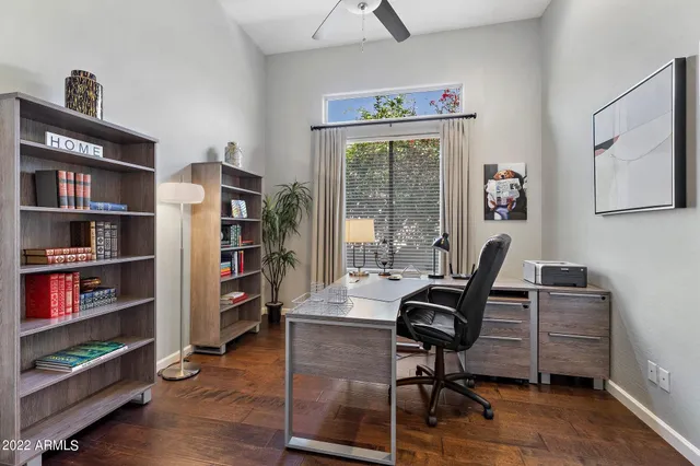 a view of a workspace with furniture and a bookshelf