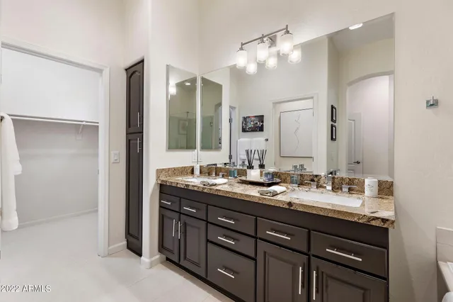 a bathroom with double vanity sinks and a mirror