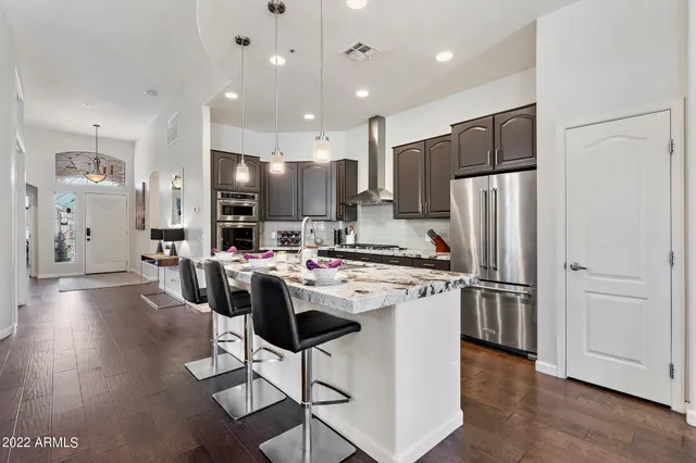 a kitchen with refrigerator and chairs