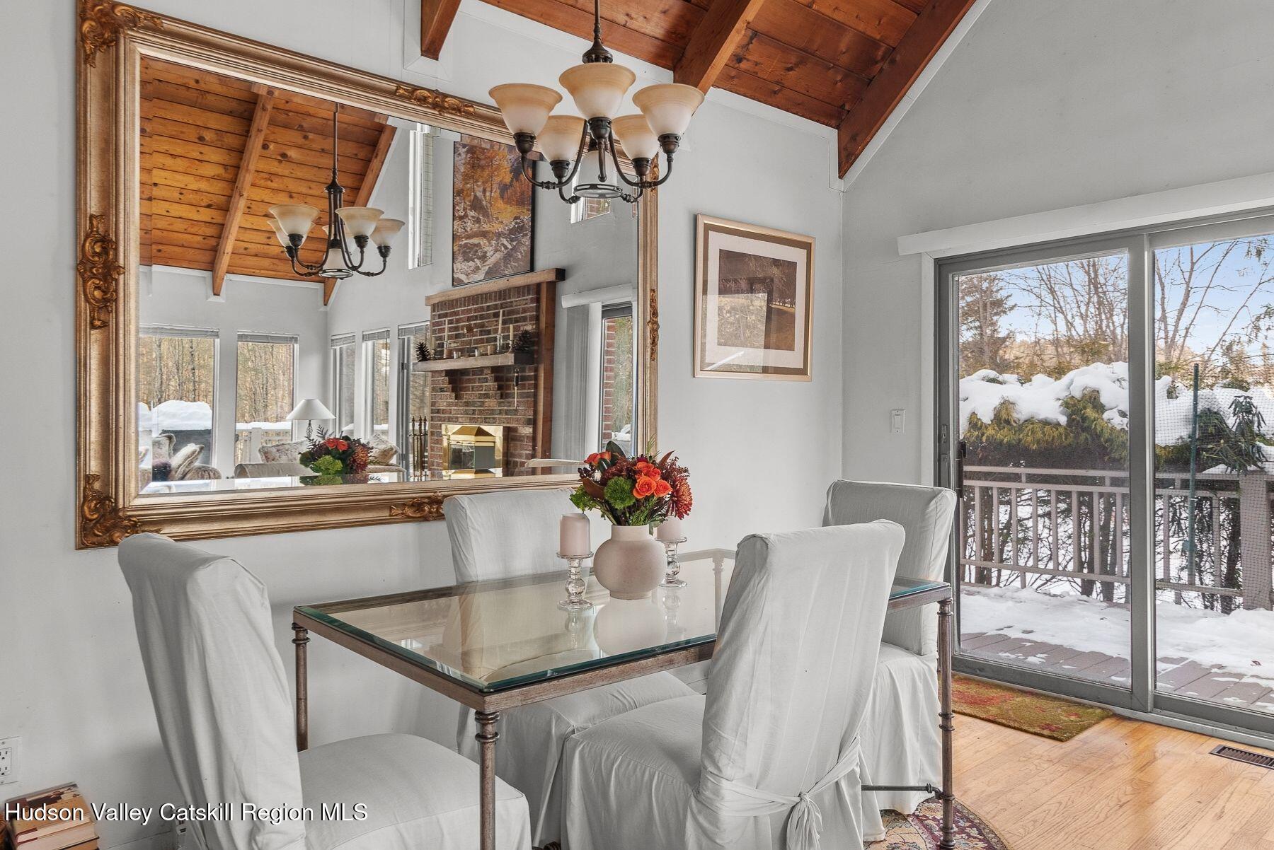 107 Ox Road Roxbury, NY 12421 - Photo 11 of 30 a dining room with furniture a floor to ceiling window and wooden floor