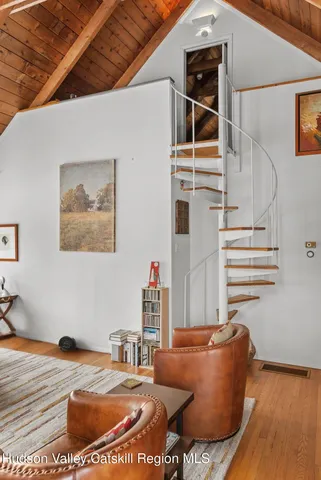 a dining room with furniture a floor to ceiling window and wooden floor